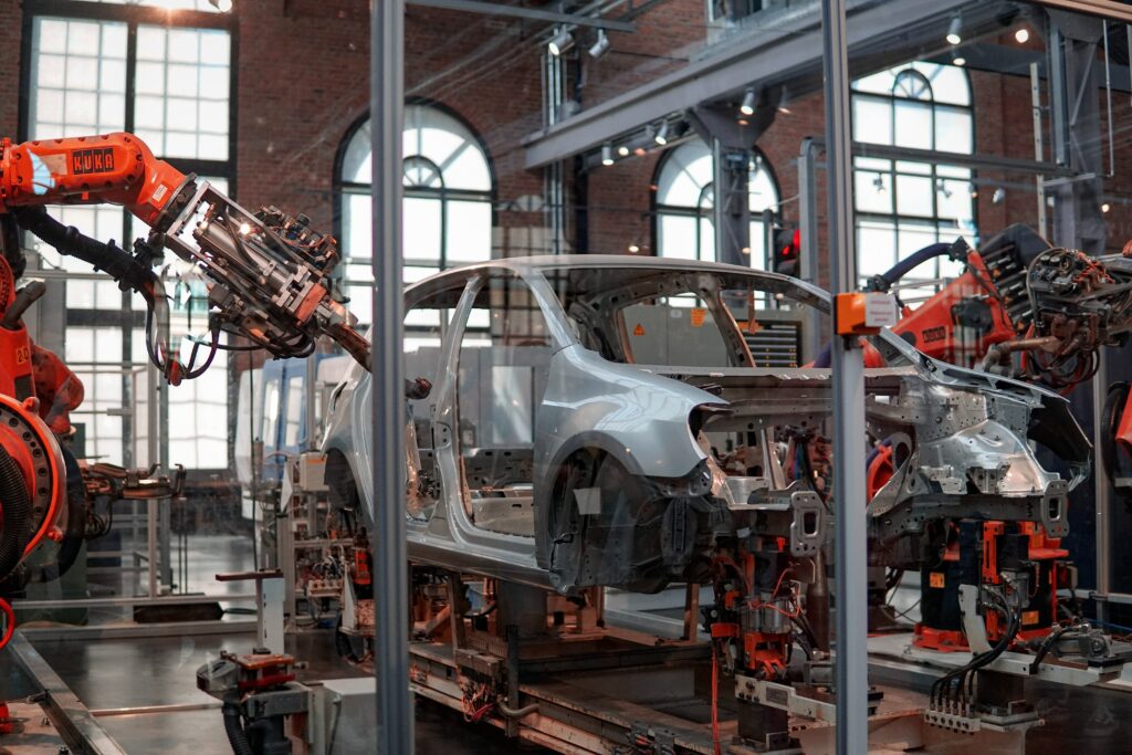 Produktionsstraße mit Roboterarm und Auto-Chassis